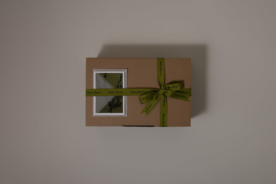 Brown gift box with a green ribbon on a plain background