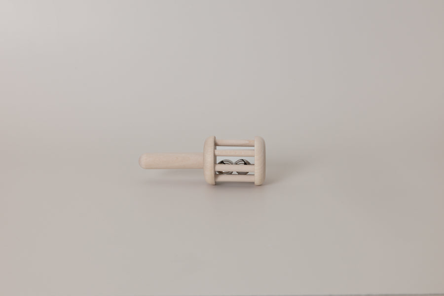 Small wooden rattle on a plain background
