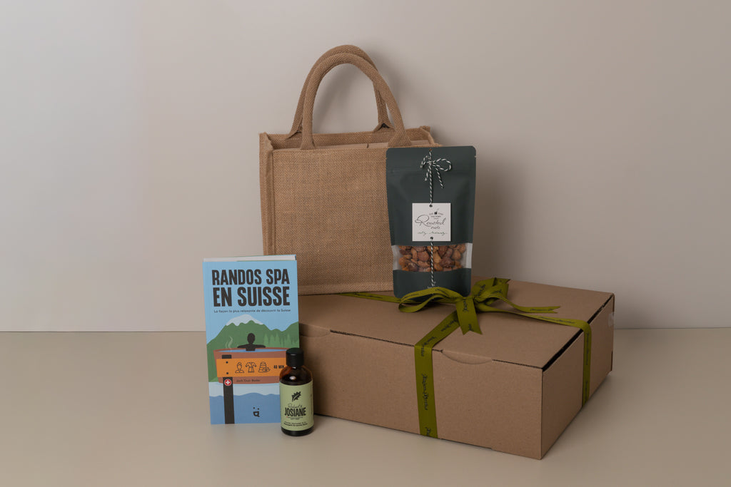 Gift set with a book, body oil, roasted nuts, and box on a neutral background
