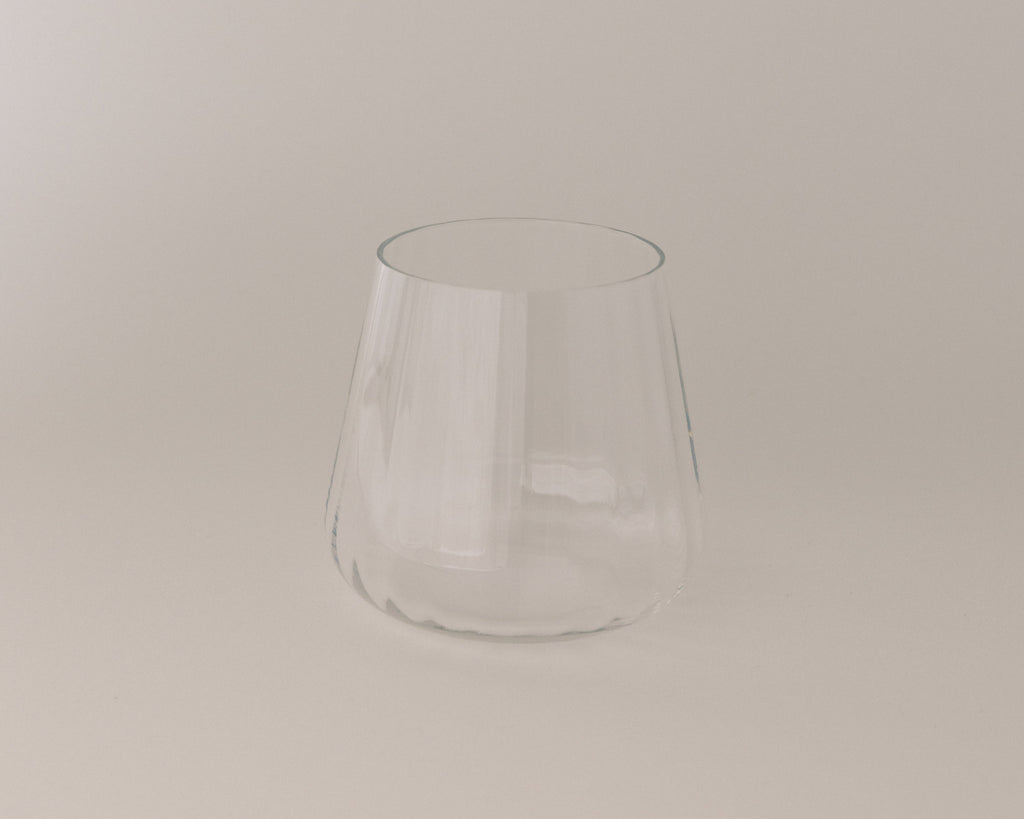 Clear glass tumbler on a beige background