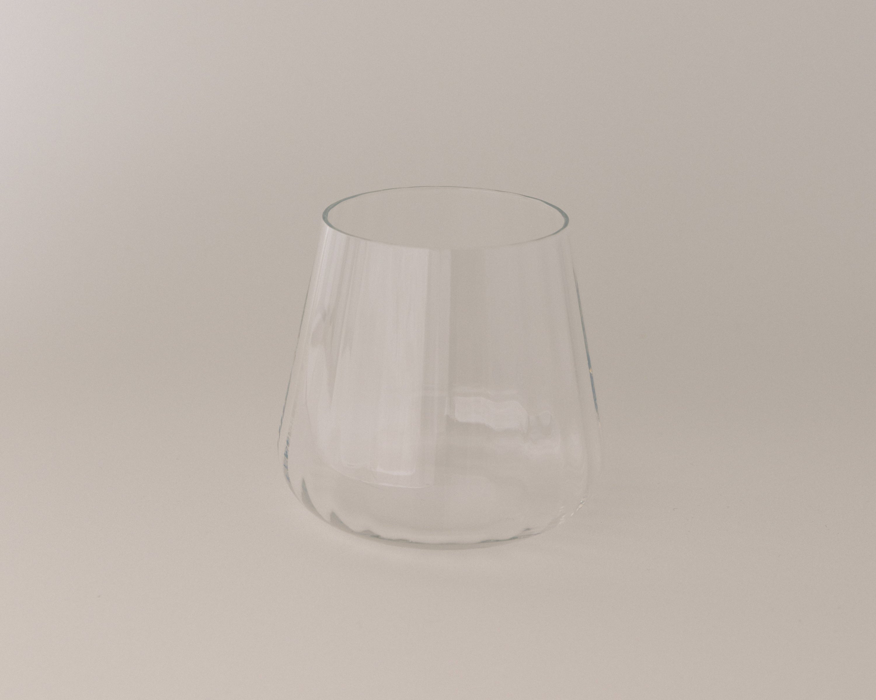 Clear glass tumbler on a beige background