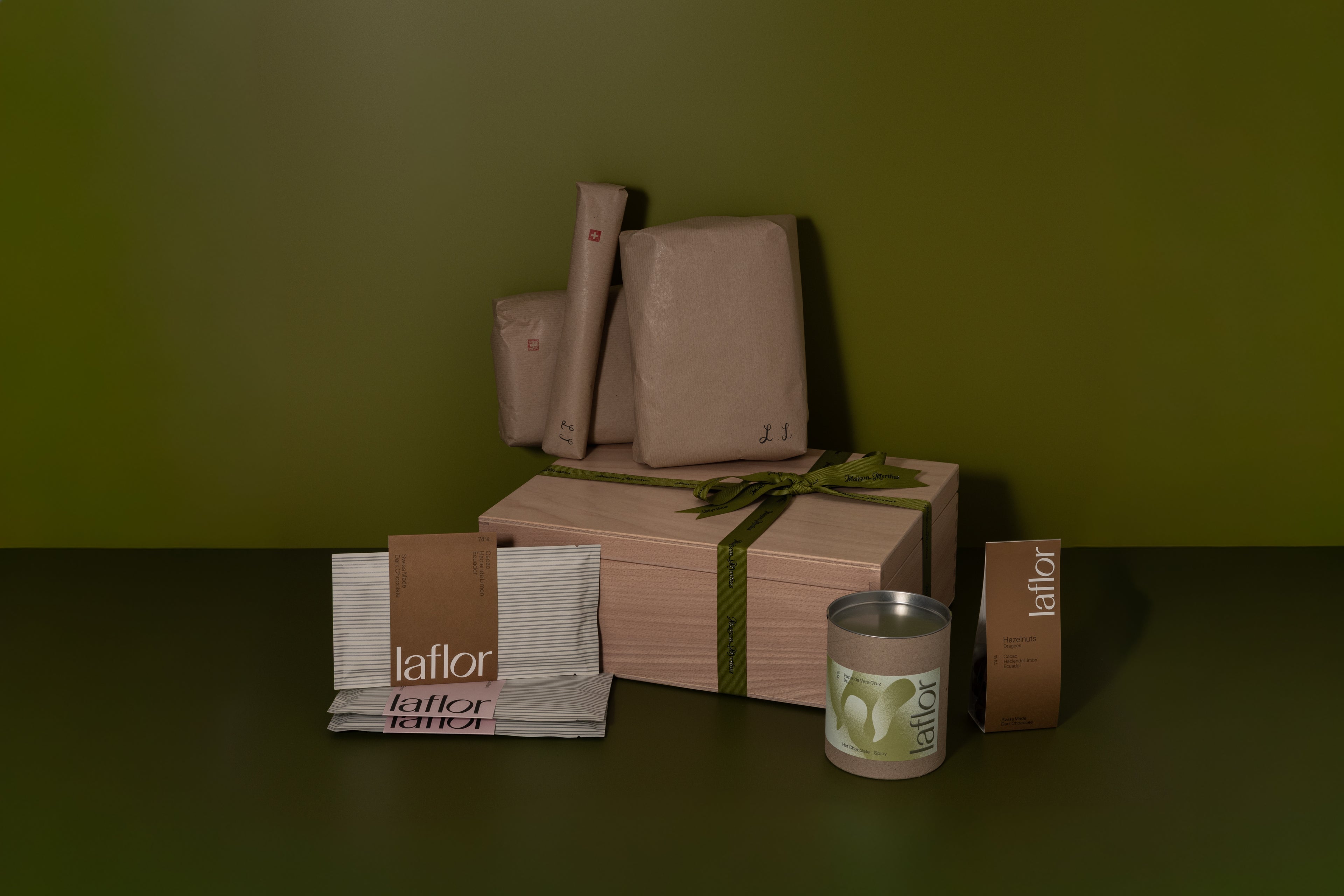 Gift boxes and wrapped items on a dark surface with a green background