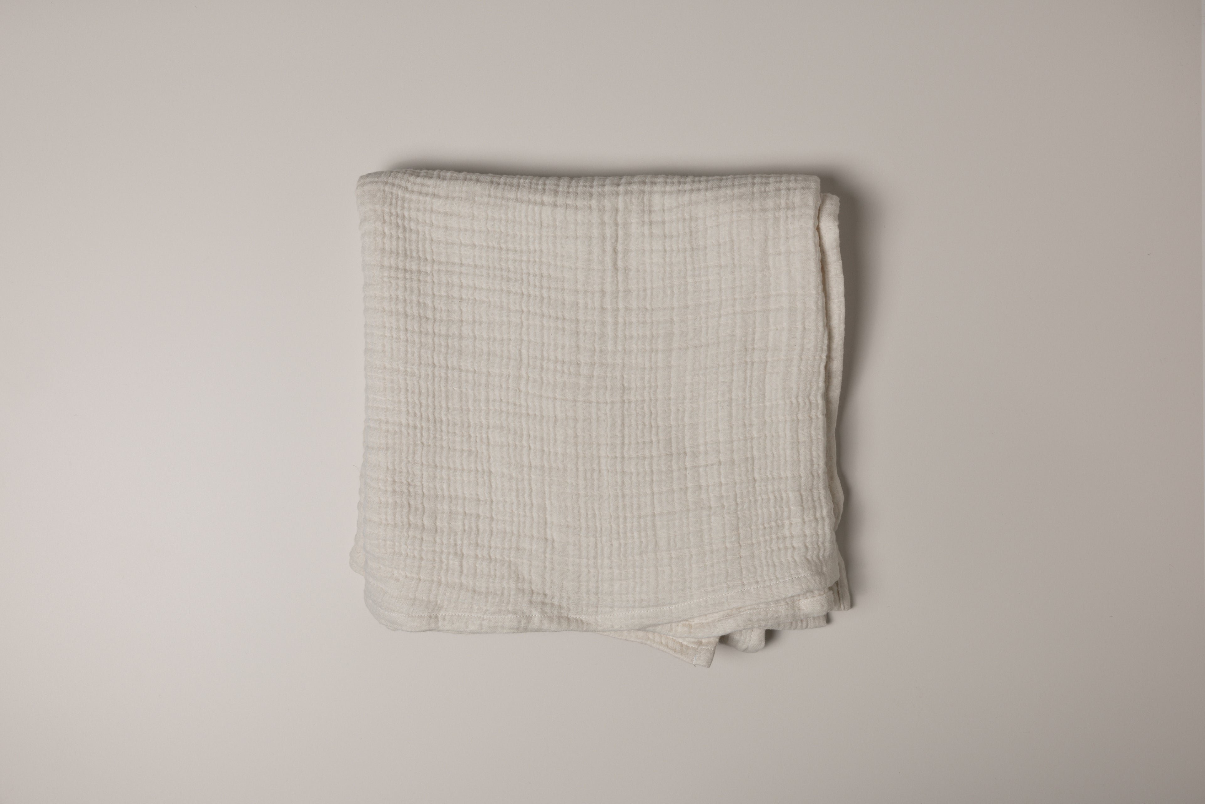 Folded muslin fabric on a plain background