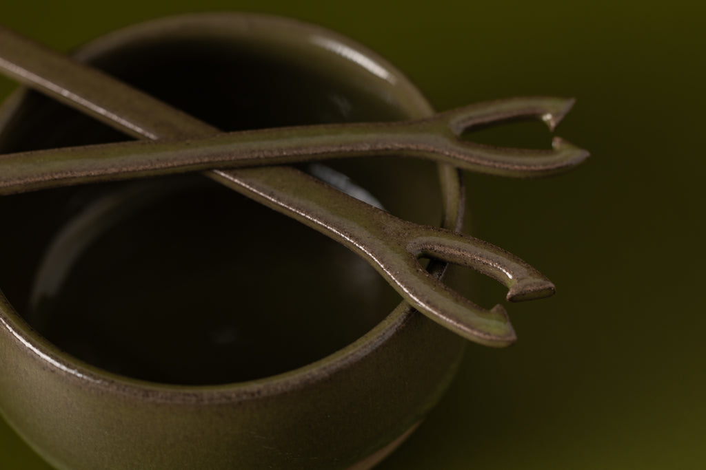 fondue fork in ceramic, green glaue on top of matching ceramic green cup