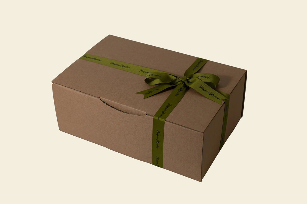 Brown gift box with a green ribbon on a light gray background