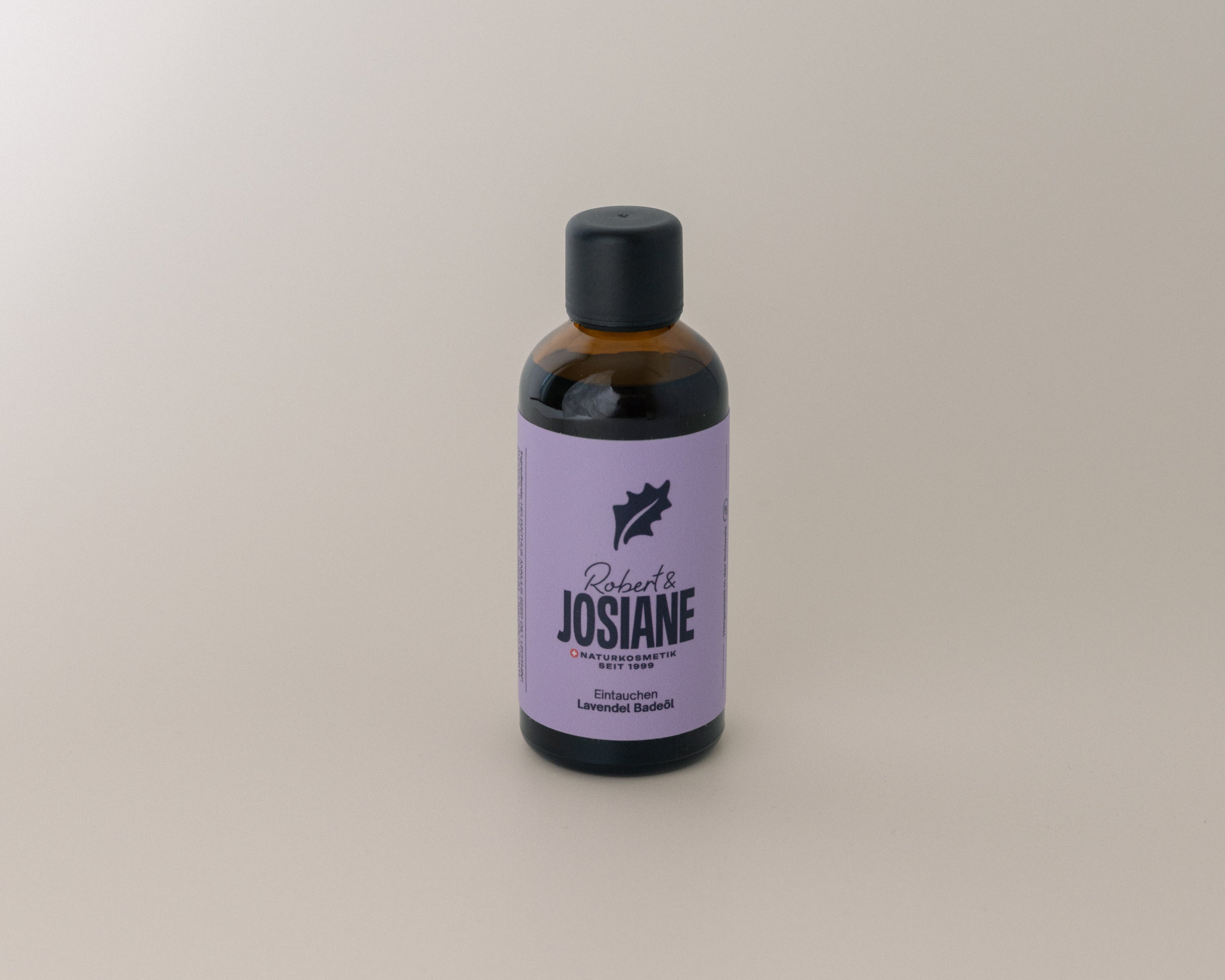 Bottle of lavender bath oil from Robert & Josiane on beige background