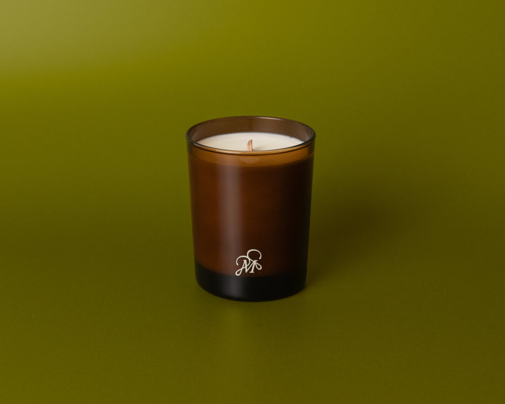 Brown candle with a logo on a green background