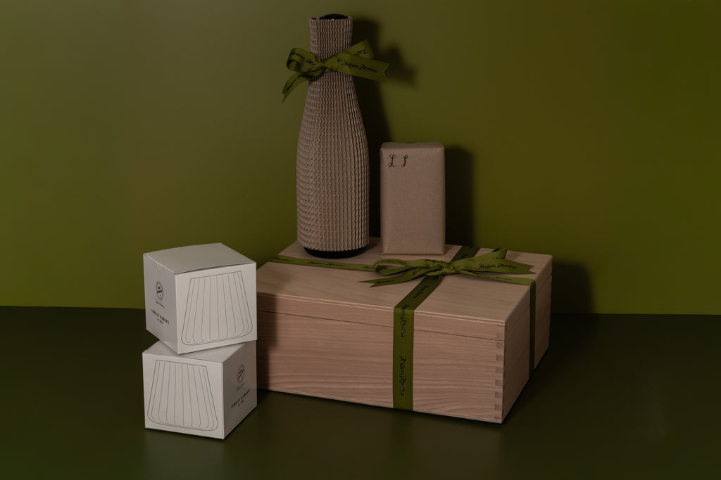 swiss gift box with wood box and products for a game night evening, with 2 tumbler glasses and a bottle of non alcoolic drink