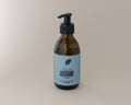 rosemary shower gel with black pump and blue label on a beige background