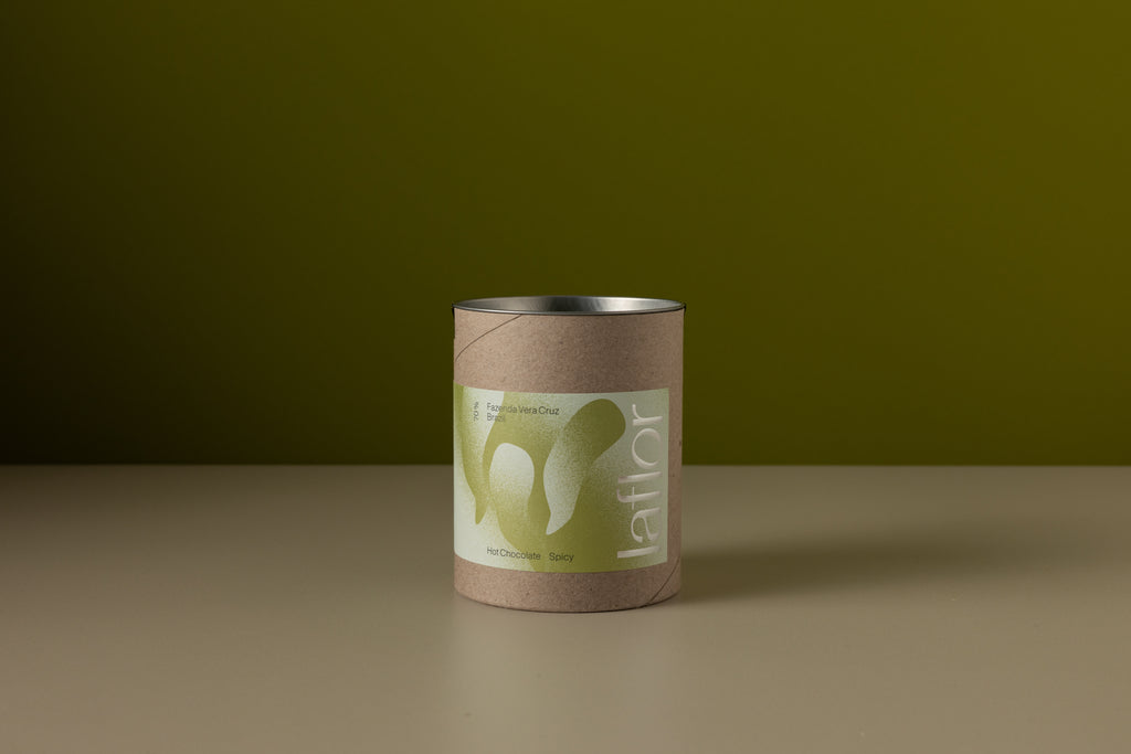 Cylindrical container with a label on a brown surface and green background