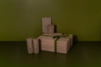 wrapped product in kraft paper with swiss floag, a box with a green ribbon on a green surface and background